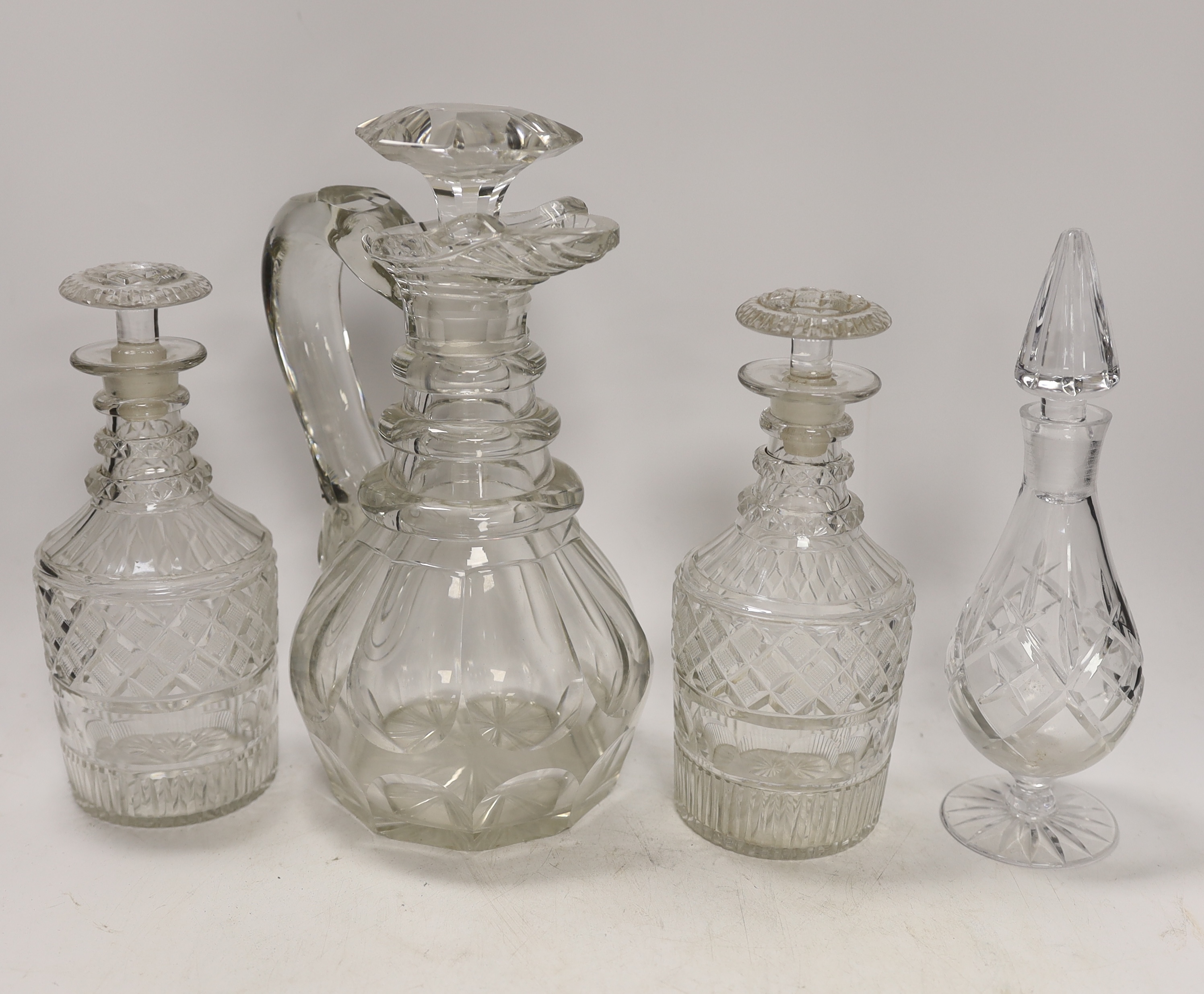 An early 19th century glass ewer, a pair of decanters and a jar, tallest 25cm